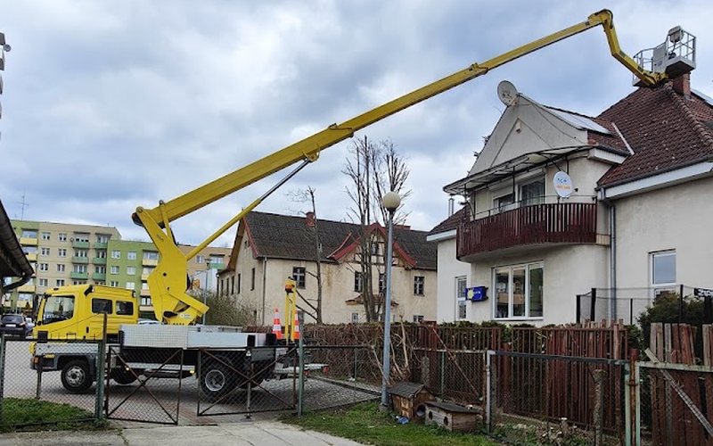 Podnośnik koszowy przy budynku podczas mycia okien i witryn